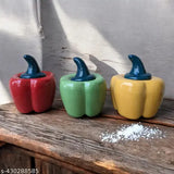 Three ceramic jars resembling bell peppers, each with a different colored lid and salt in one. Multi-colored design, round shapes, lids not fully closed, salt inside one jar