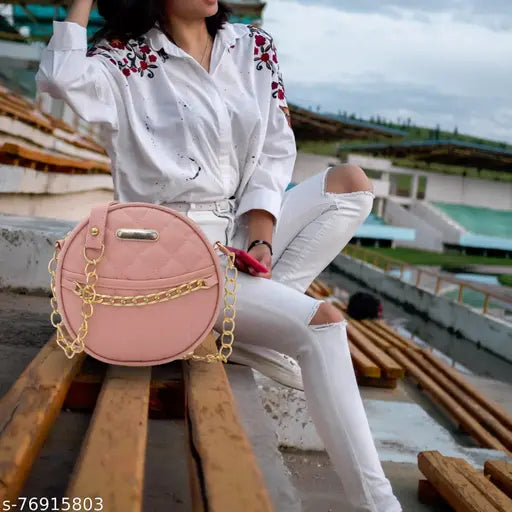 Bright pink faux leather slingbag with multiple compartments, large front pocket and chain shoulder strap