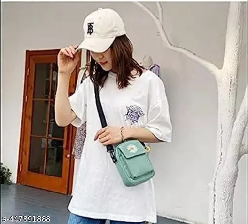 A person wearing a white t-shirt and jeans, accessorizing with a green Canva bag, posing in front of a building