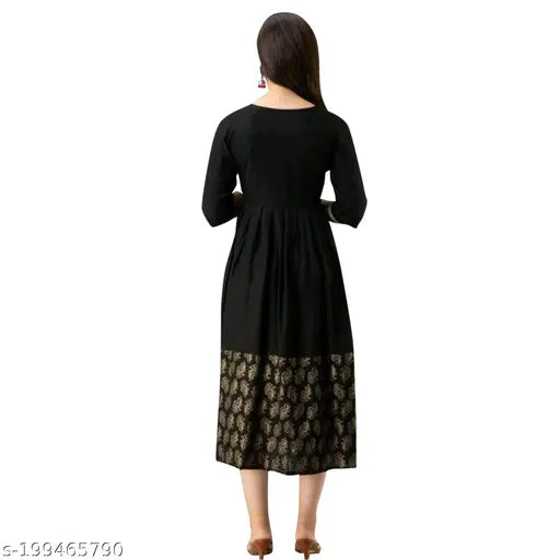 Black long kurti with gold print detailing a person standing on the right