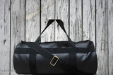 Black leather duffle bag, strap closure, 12 pockets