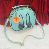 Fashionable sling bag with blue background, black and gold bow embellishment