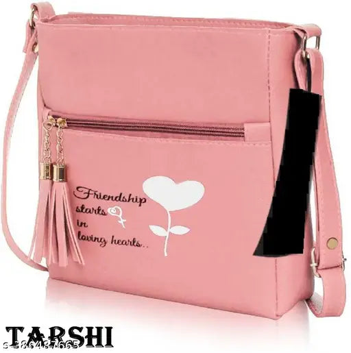 A hot pink sling bag with a heart design, zip closure, and a tassel accent