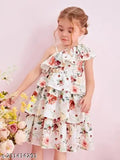 Female child in white dress with off-shoulder design, floral pattern and ruffled sleeves