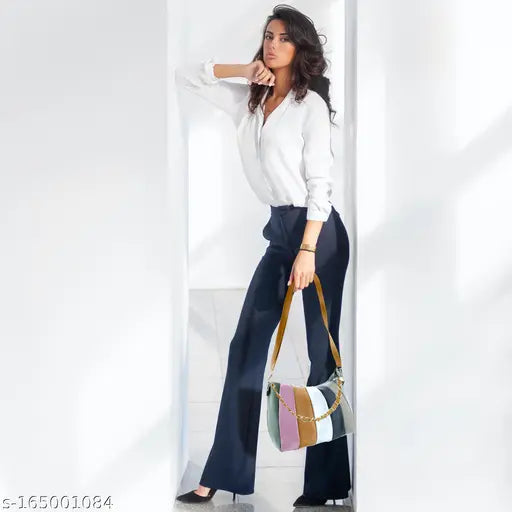 Woman in sleek high heels holding a sling bag with various colors, possibly faux leather or satin fabric, against a neutral background