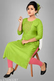 A woman wearing a green kurta sitting on a chair