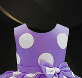 Purple dress with white polka dots, purple bow at neck, and matching pink scarf