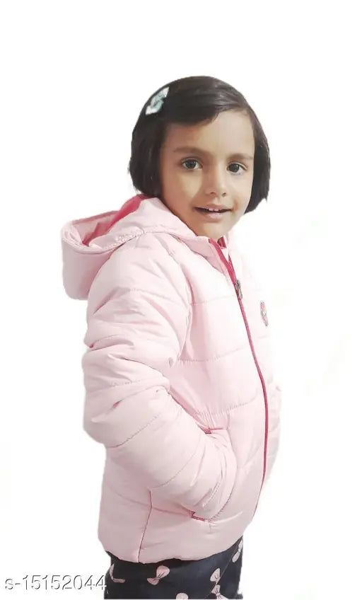 A child in a pink jacket with a hood, posing against a white background