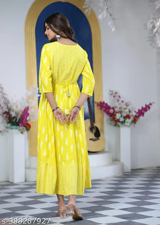 A person wearing a yellow kameez on a stage with decorations