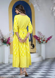 A person wearing a yellow kameez on a stage with decorations