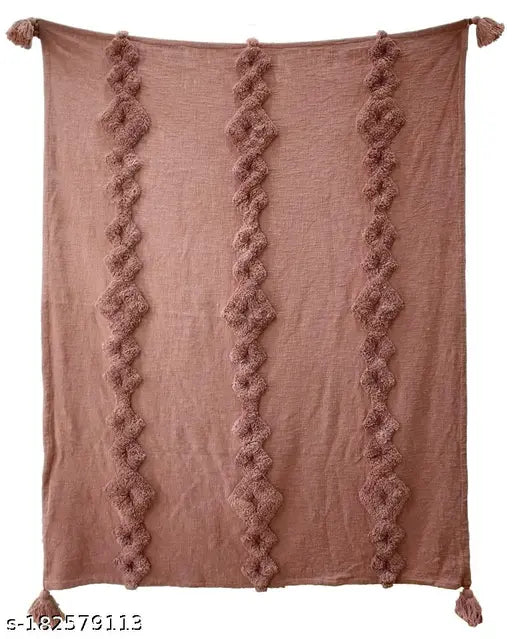 A pink soft plush throw rug, featuring a chain tuft pattern and tassels on all corners