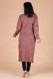 The image features a woman walking in an outdoor setting. She is wearing a long, dark brown or maroon kurta with sleeves and pants. It's loose-fitting and appears to be a traditional Indian garment. The kurta has a straight cut across the chest area, which could suggest a modern, slightly tailored style rather than a more traditional silhouette