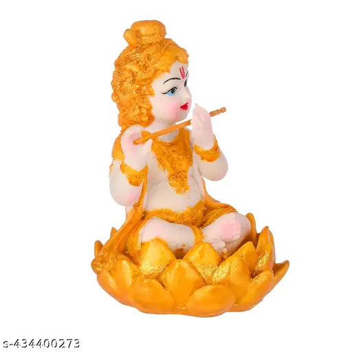 Golden statue of baby Krishna, seated in a golden lotus. A representation of Hindu deity Lord Krishna, adorned with garlands, as a home decor item or a pooja murti