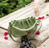 Green faux leather sling bag with pearl accents, adjustable strap