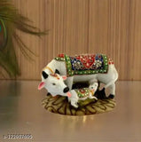 This is a decorative sculpture of a cow and calf. It is made from marble dust polyresin and is big in size. The sculpture features detailed spiritual vastu designs, inspired by the Nandi Pooja figure. It has multiple colors and can be used as a showpiece or decorative item