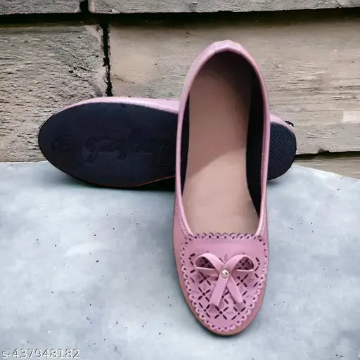 A pair of pink crocheted slip-on shoes with a bow on top
