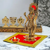 A bronze idol of Lord Vishnu, adorned with a red flower garland and gold jewelry, atop a white marble lotus. Flanked by traditional puja items such as diyas, conch shells, and ritual offerings. Accompanied by various other religious symbols and deity idols