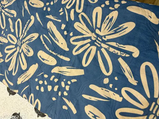 Blue and white floral quilt with a patterned backing