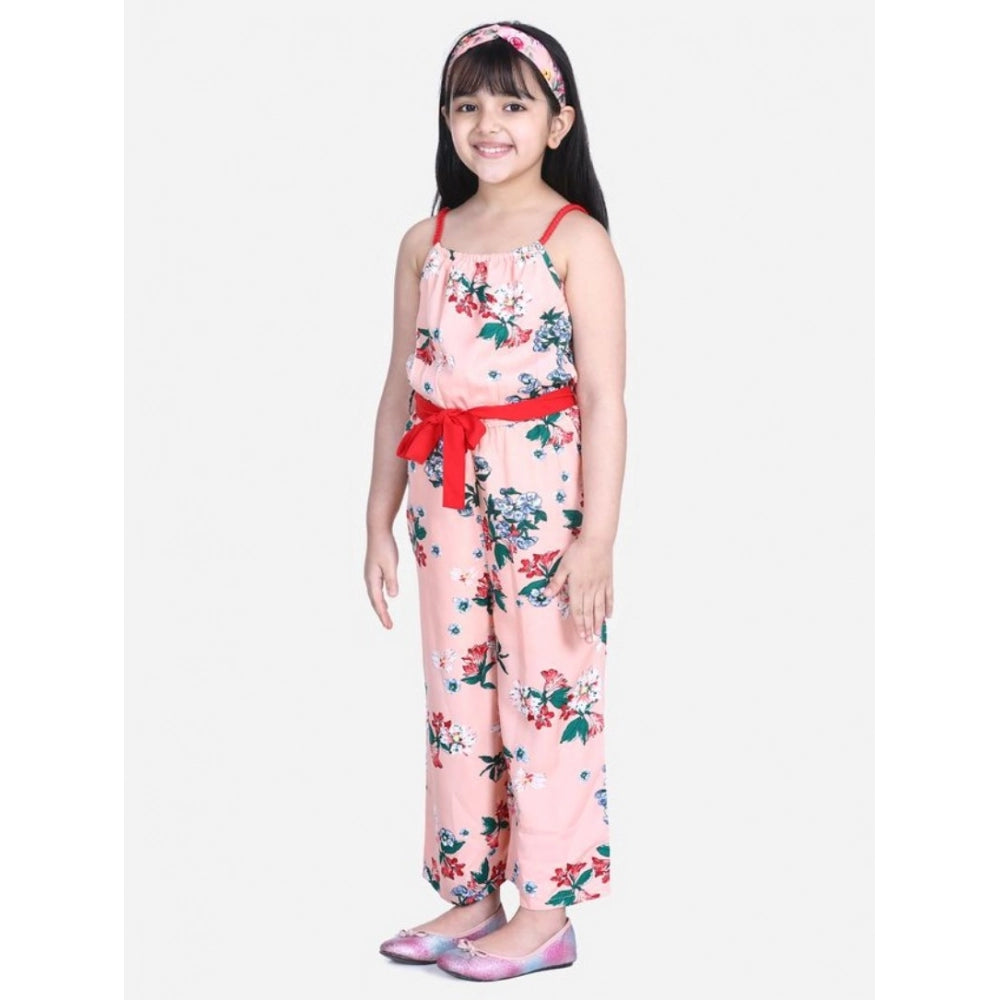 Peach-red floral polyester crepe girl's jumpsuit with shoulder straps, square neckline on model