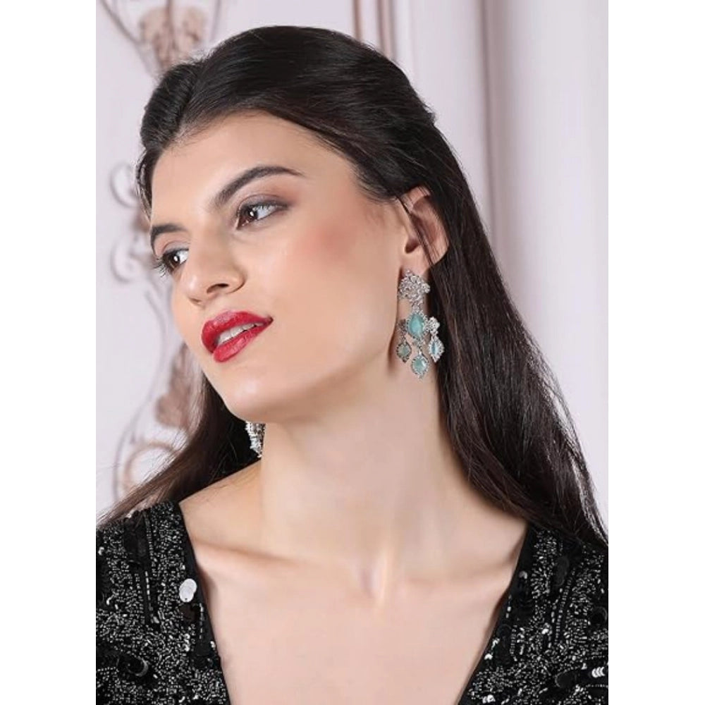 Women's brass silver-plated turquoise drop earrings, delicate jewelry accessory on display stand