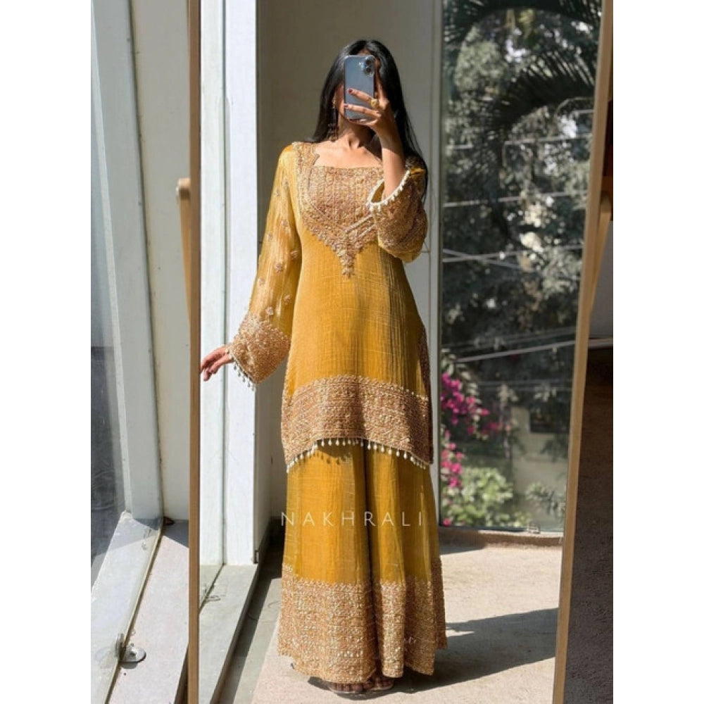 Yellow silk embroidered 3/4th sleeve round kurti set with sharara pant and dupatta, intricate design on display stand