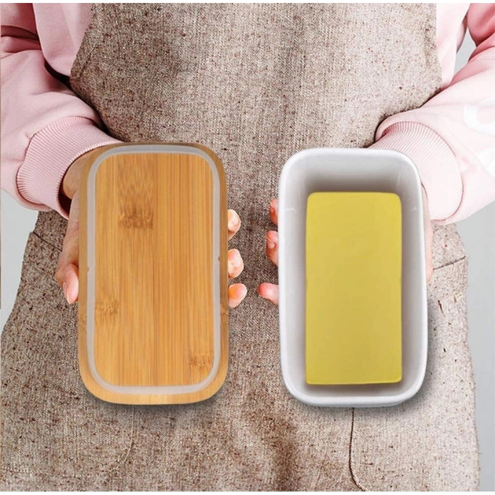 { "alt_text": "White ceramic butter box with bamboo lid, airtight storage container for fresh butter, kitchen countertop accessory" }