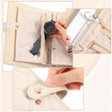 { "alt_text": "Beige PU leather jewelry organizer book with velvet interior, expandable jewelry storage box for women's accessories" }