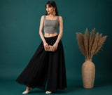 { "alt_text": "Black georgette women's palazzo pants, solid mid-rise wide leg flared pants, ankle length ethnic wear" }