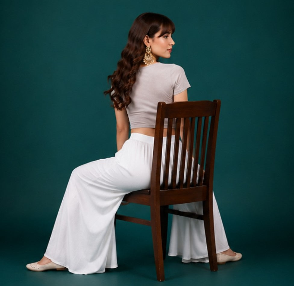 { "alt_text": "White georgette women's palazzo pants, solid mid-rise wide leg flared pants, ankle length ethnic wear" }