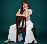 { "alt_text": "White georgette women's palazzo pants, solid mid-rise wide leg flared pants, ankle length ethnic wear" }