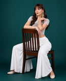 { "alt_text": "White georgette women's palazzo pants, solid mid-rise wide leg flared pants, ankle length ethnic wear" }