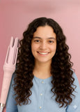 Pink plastic and stainless steel automatic hair curler with adjustable temperature settings for styling hair