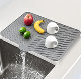 Grey silicone dish drying mat with built-in drain spout, non-slip, and heat resistant for kitchen use