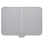 Grey silicone dish drying mat with built-in drain spout, non-slip, and heat resistant for kitchen use