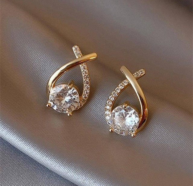 Gold plated brass stud earrings featuring a crossover twirl design, sold as a pair for women