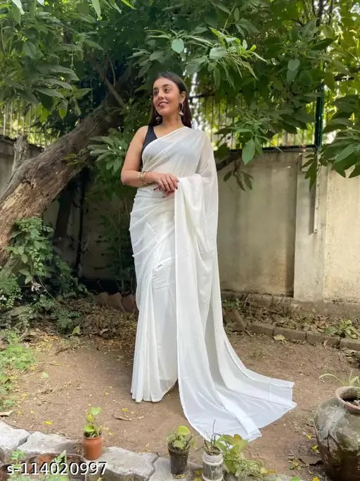 White Georgette saree, woman standing, plain background