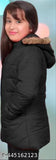 The image shows a young woman posing in a long coat, possibly of black material with a hood