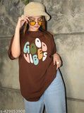 A woman wearing a casual printed round neck oversized T-shirt with the word "good vibes" on it, paired with sunglasses and jeans