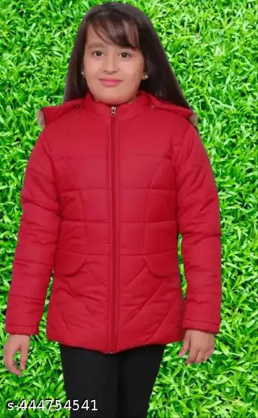 A red coat with a hood, worn by a girl standing against a green wall