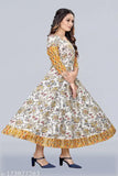 This is an image of a woman wearing a long, flared, colorful kurta with short sleeves and a patterned front panel. The kurta features a vibrant floral print and is adorned with what appears to be silver foil accents or embellishments on the bodice area