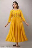 A woman in a vibrant yellow mustard Anarkali kurta with embroidered borders, standing against a white background