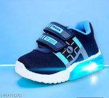 The image displays a pair of sports shoes with a blue colorway, black straps, and a chunky sole design. They appear waterproof and suitable for casual wear or sporting activities. The shoes have a comfortable appearance, likely designed for comfort and style. The image is brightly lit, showcasing the shoes' details against a contrasting background