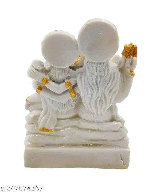 White idol depicting Lord Shiva, Lord Ganesh, and Maa Parvati, with gold accents and small temple flags