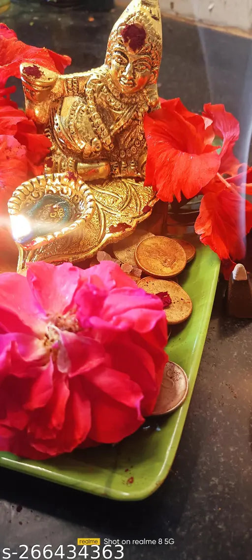 Yellow and red divinity Diwali decoration, lit diya, wooden table background