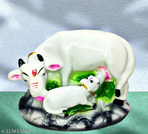 A statue of a cow with a calf in its belly, rendered in white and pink on a green base