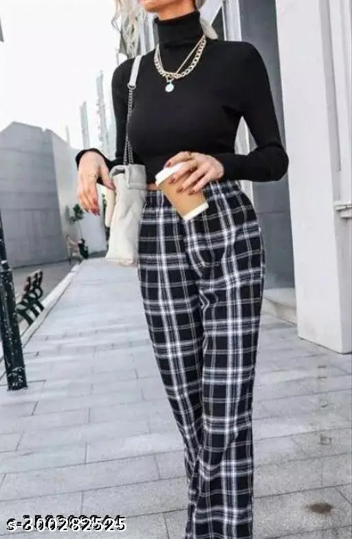 A woman wearing black plaid pants and a black top