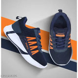 The image shows a pair of navy blue slip-on athletic shoes with orange accents. They have white soles and are designed for outdoor and indoor running, walking or casual wear. The shoes feature a strap over the top for fast and easy on and off. These sneakers can be worn all day for comfort and style. Ideal for baby boys as part of their active wardrobe