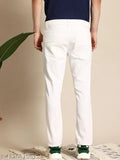 The image displays a pair of white jeans worn by an individual, with visible features including button closure, belt loops, and a casual fit. The person is also wearing sneakers with green laces