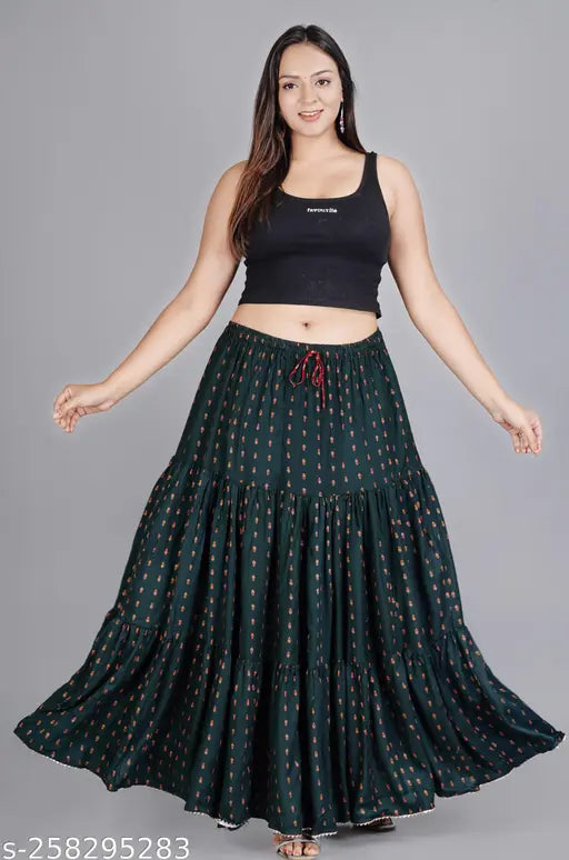 Green printed rayon long skirt for women, featuring intricate design on net fabric. Available sizes: 34/18in, 36/19in, 38/19in, 40/20in, 42/21in, 44/22in, 46/23in, 48/24in, Free Size/25in (Made in India)