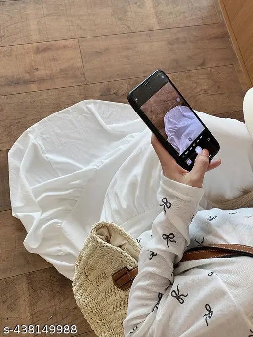 A person is holding a cell phone with a photo of another person on it while standing on a rug